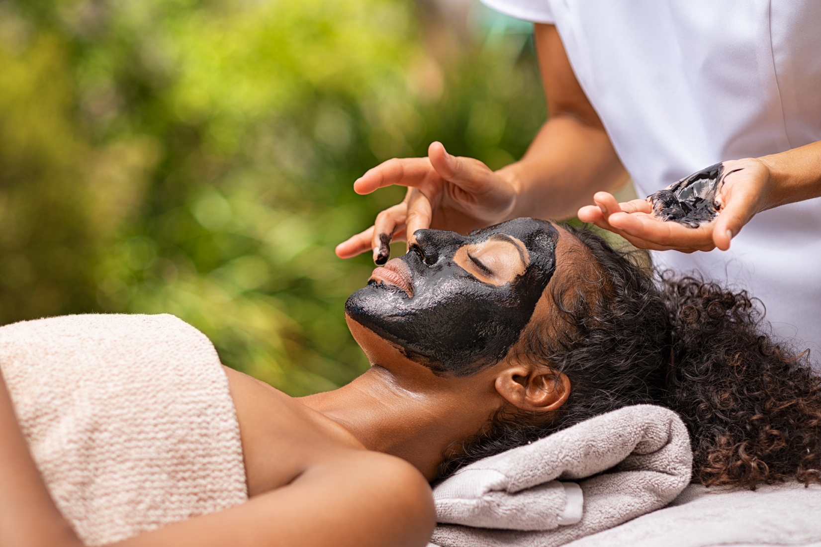 woman getting-charcoal-facial-at-beauty-resort-H3M97UW